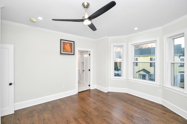 empty room featuring crown molding, ceiling fan, and dark wood-type flooring