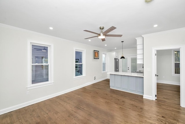 kitchen with dark wood-type flooring, crown molding, ceiling fan, decorative light fixtures, and stainless steel refrigerator