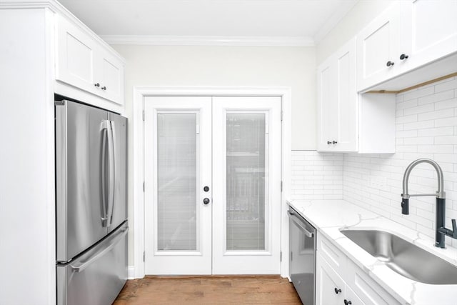 kitchen featuring white cabinets, sink, light hardwood / wood-style floors, light stone counters, and stainless steel appliances