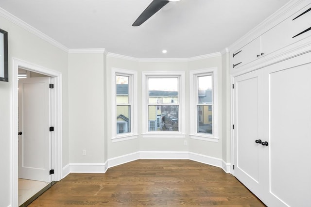 empty room featuring ceiling fan, dark hardwood / wood-style floors, and ornamental molding