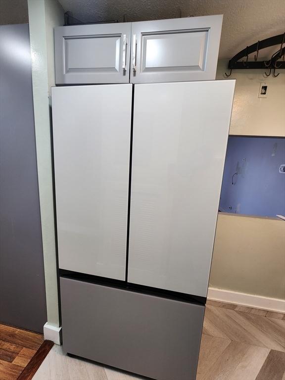 interior details with baseboards and freestanding refrigerator