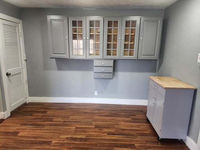 interior space featuring dark wood-type flooring and baseboards