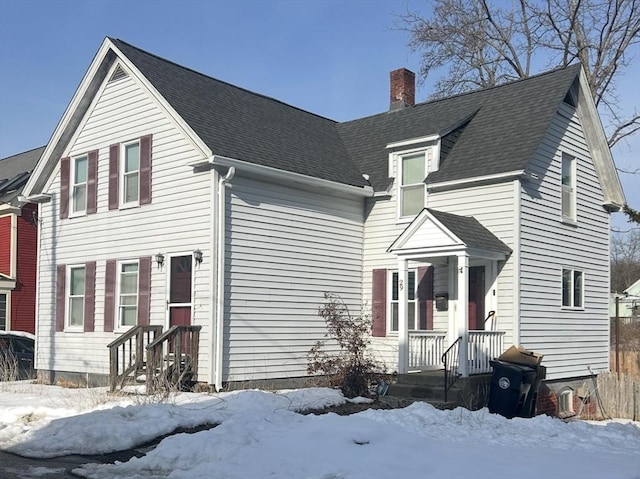 view of front of home featuring roof with shingles and a chimney