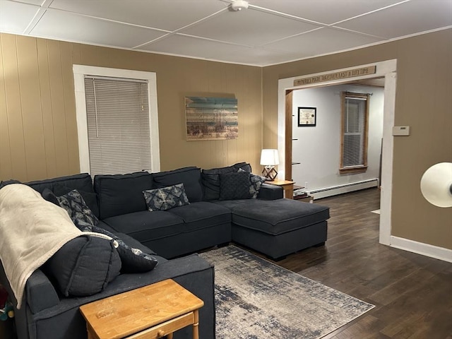 living room featuring a baseboard heating unit, wood finished floors, and baseboards