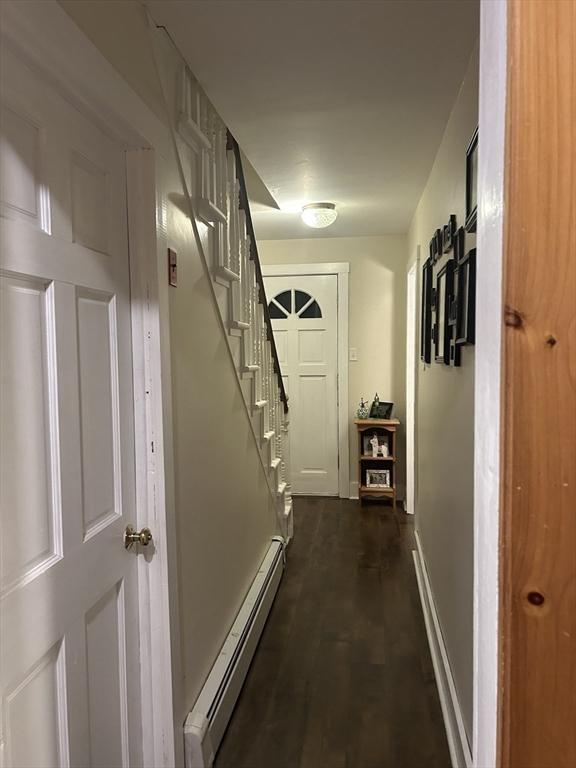 corridor featuring baseboards, stairs, and a baseboard heating unit