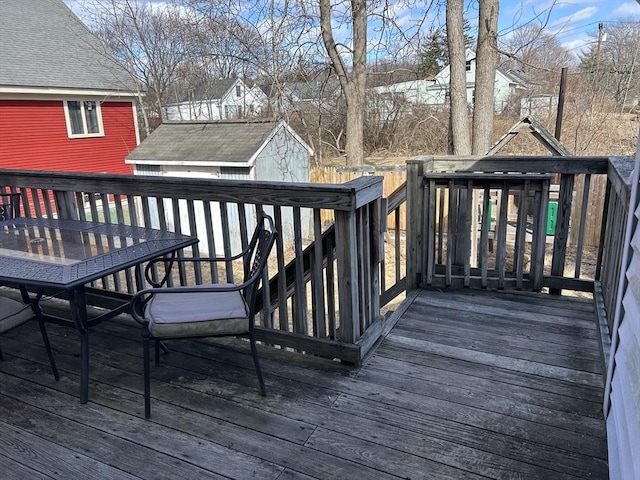 wooden terrace with outdoor dining space and an outbuilding