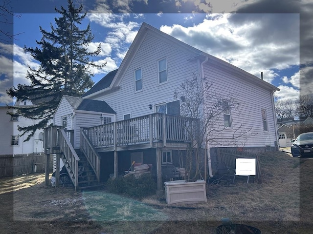 rear view of house with stairway, fence, and a wooden deck