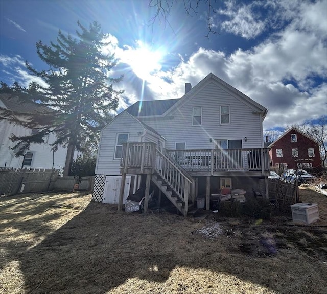 rear view of property with stairway, a chimney, fence, and a wooden deck