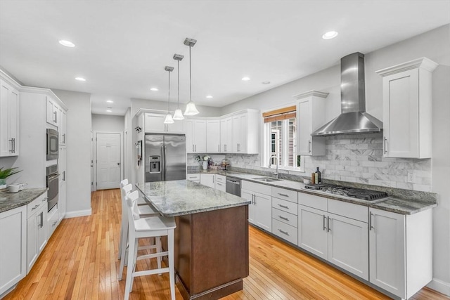 52 Sylvan Dr, Stow, MA 01775 - kitchen featuring appliances with stainless steel finishes, wall chimney exhaust hood, light wood finished floors, a kitchen island, and recessed lighting