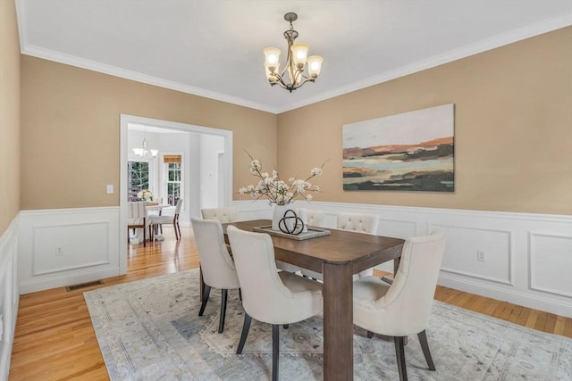 52 Sylvan Dr, Stow, MA 01775 - dining space featuring a chandelier, light wood-type flooring, a wainscoted wall, ornamental molding, and a decorative wall