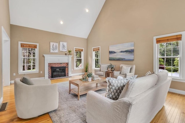 52 Sylvan Dr, Stow, MA 01775 - living room featuring light wood-type flooring, high vaulted ceiling, a fireplace, and recessed lighting
