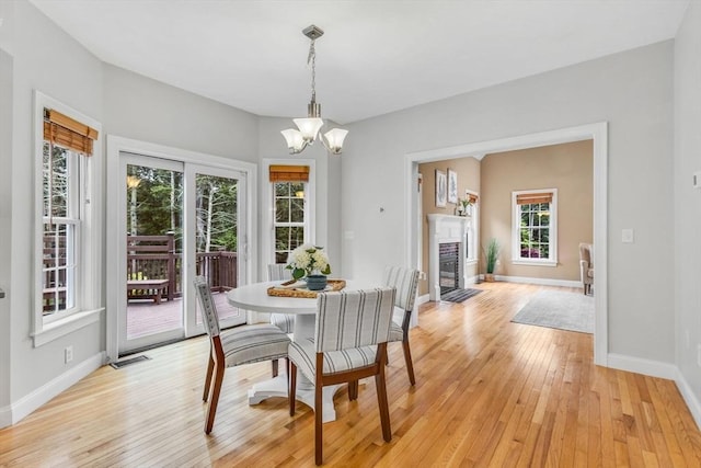 52 Sylvan Dr, Stow, MA 01775 - dining room with light wood-style flooring, a chandelier, and a fireplace with flush hearth