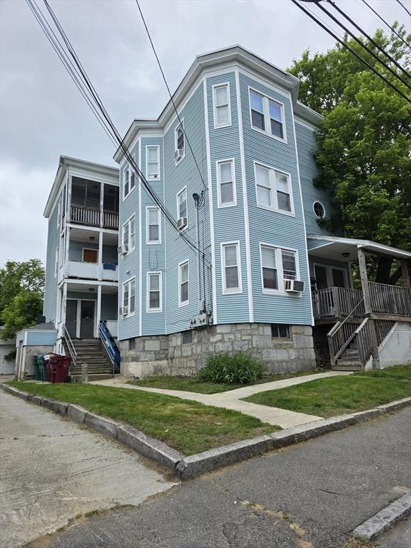 133 Mount Vernon St, Lowell, MA 01854 - view of front facade with cooling unit, stairs, and a balcony