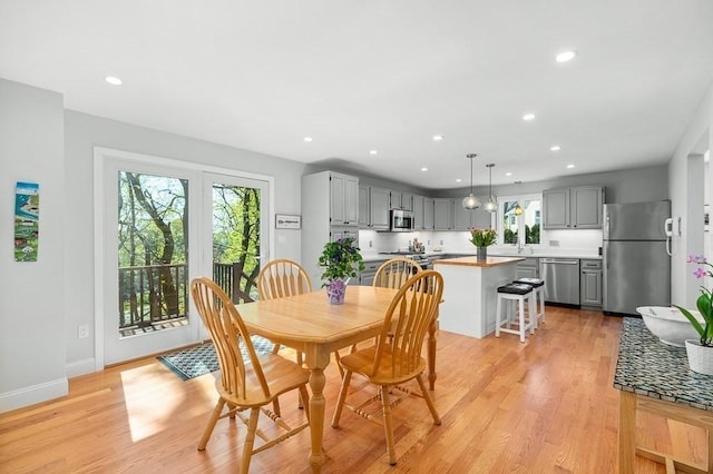 dining room with recessed lighting, baseboards, and light wood finished floors