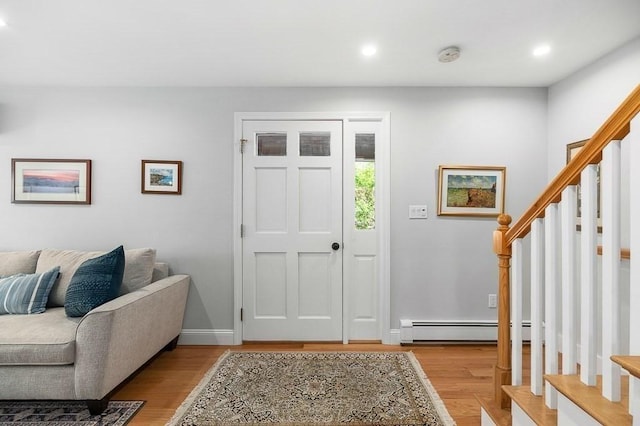 entryway with light wood-style floors, recessed lighting, a baseboard radiator, and stairs
