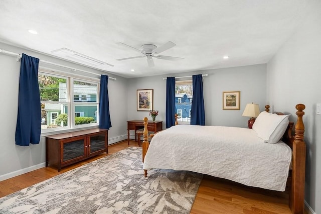 bedroom with recessed lighting, ceiling fan, multiple windows, and wood finished floors