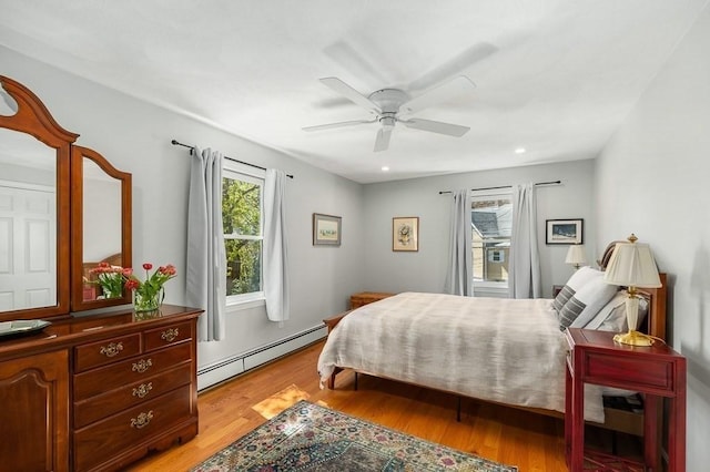 bedroom featuring recessed lighting, a ceiling fan, light wood finished floors, and a baseboard heating unit