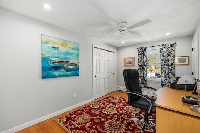 home office featuring light wood finished floors, a ceiling fan, baseboards, recessed lighting, and a baseboard radiator