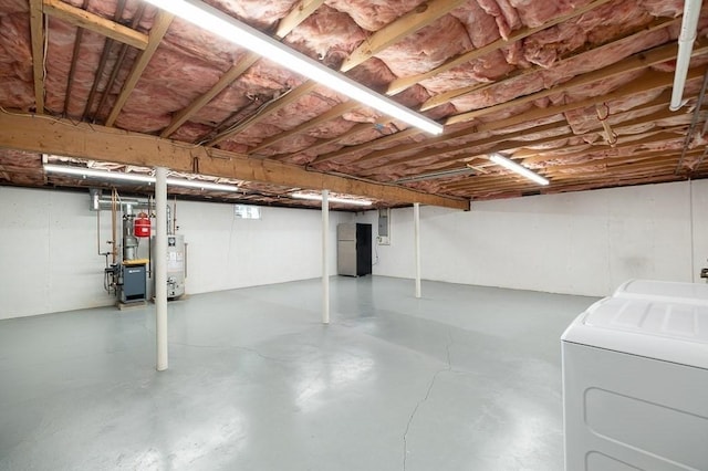 unfinished below grade area with gas water heater, washer / clothes dryer, and a heating unit