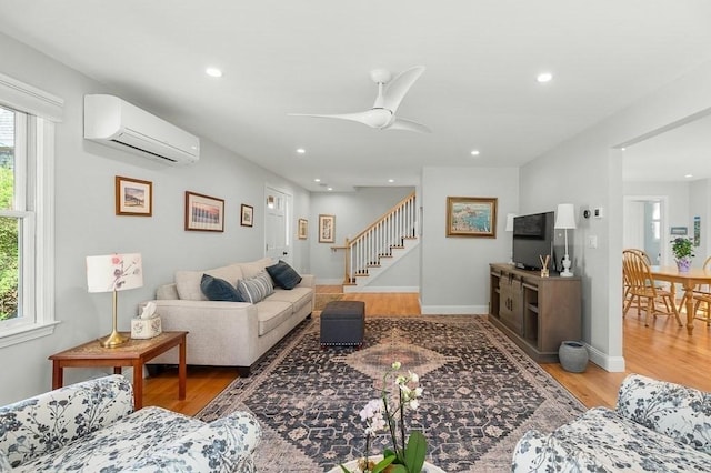 living area featuring recessed lighting, stairs, a wall mounted air conditioner, and wood finished floors