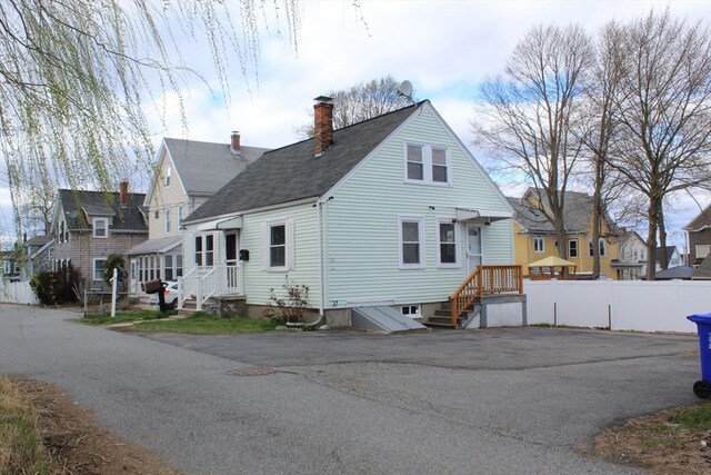 exterior space featuring a residential view, a chimney, and fence