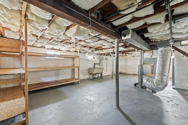 basement with concrete block wall and a sink