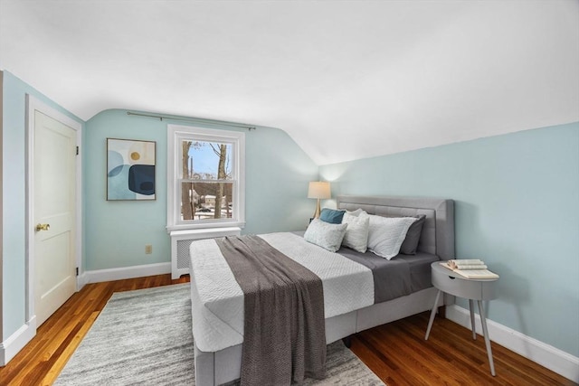 bedroom featuring lofted ceiling, radiator, and wood-type flooring