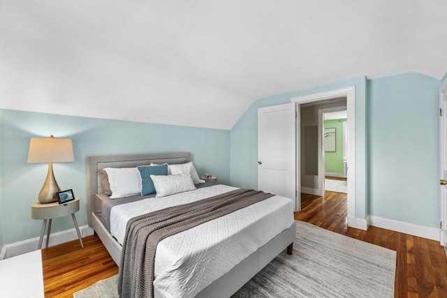 bedroom featuring wood-type flooring and vaulted ceiling