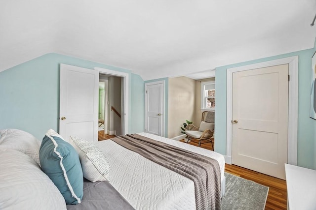 bedroom with hardwood / wood-style flooring and vaulted ceiling