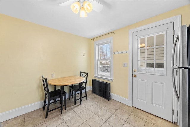 dining space with radiator, light tile patterned floors, and ceiling fan
