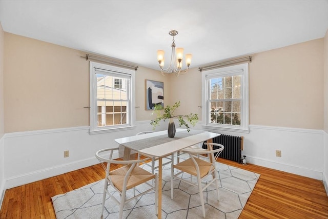 dining area with a chandelier, radiator, light hardwood / wood-style floors, and a wealth of natural light