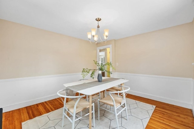 dining room with light hardwood / wood-style flooring and a chandelier