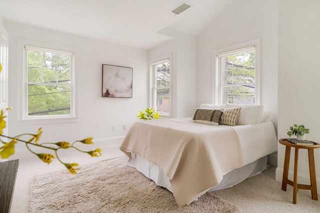 carpeted bedroom featuring multiple windows, baseboards, and vaulted ceiling