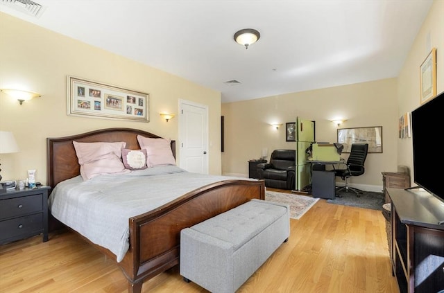 bedroom with light wood-style floors and visible vents