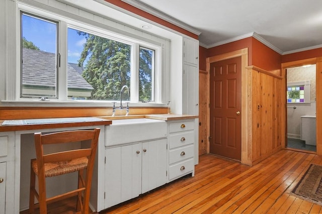 47 Stetson, Haverhill, MA 01835 - kitchen with light wood-type flooring, a sink, white cabinets, light countertops, and ornamental molding