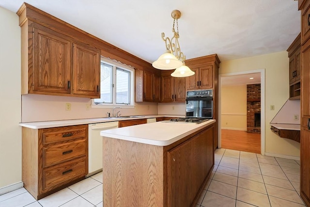 kitchen with sink, dishwasher, hanging light fixtures, a kitchen island, and oven