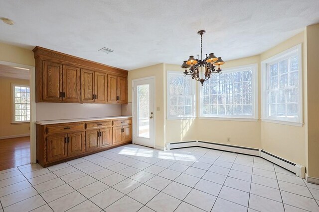 kitchen with hanging light fixtures, light tile patterned floors, a chandelier, and baseboard heating