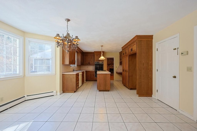 kitchen with a kitchen island, decorative light fixtures, black double oven, light tile patterned floors, and a notable chandelier