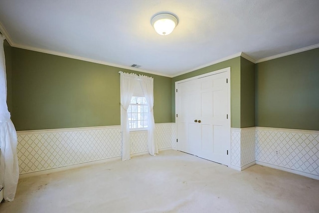 unfurnished bedroom with ornamental molding, light carpet, and a closet