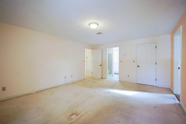 unfurnished bedroom with light colored carpet and a closet