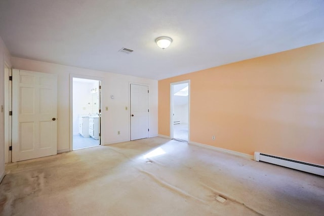 carpeted spare room featuring baseboard heating