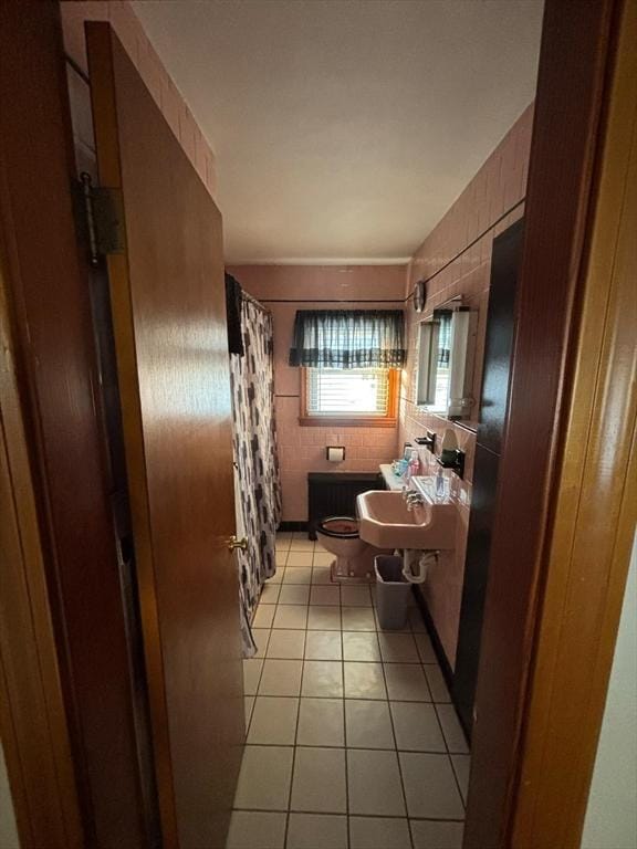 full bathroom featuring tile patterned flooring, a shower with curtain, tile walls, and toilet