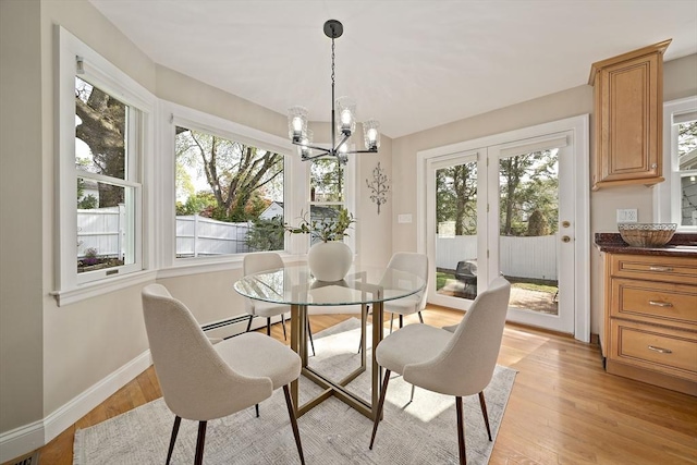 dining room featuring baseboards, light wood-style floors, a wealth of natural light, and french doors