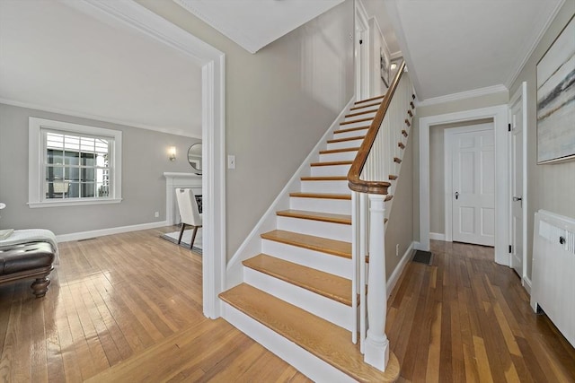 stairs with baseboards, ornamental molding, and hardwood / wood-style flooring