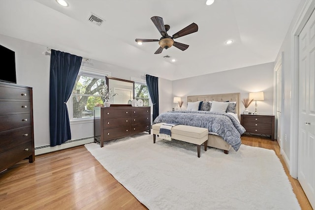 bedroom with light wood-style floors, a baseboard heating unit, recessed lighting, and visible vents