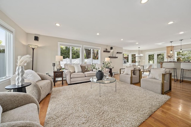 living room with recessed lighting, an inviting chandelier, light wood-style flooring, and a baseboard radiator