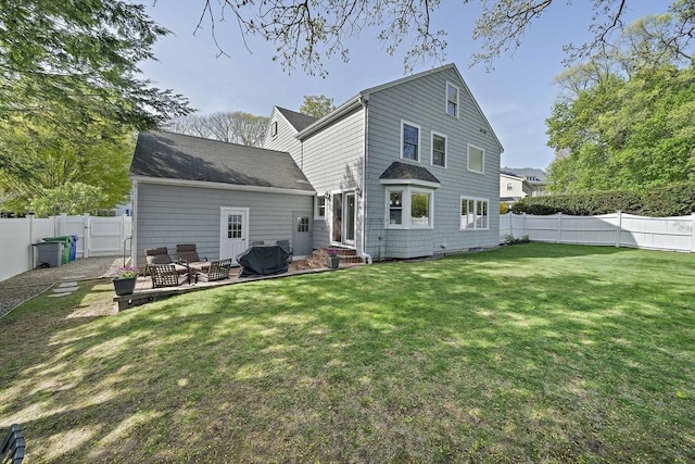 back of property with a yard, a fenced backyard, and a patio area