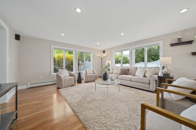 living room with recessed lighting, plenty of natural light, baseboard heating, and wood finished floors