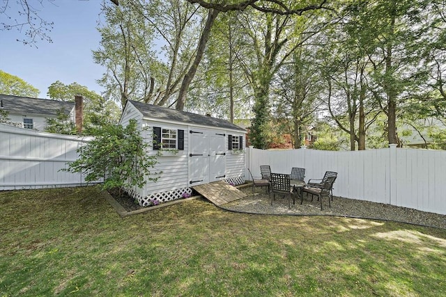 exterior space with a fenced backyard, a storage unit, and an outbuilding