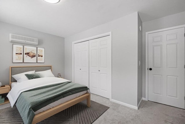 bedroom with a closet, a wall mounted air conditioner, baseboards, and carpet floors